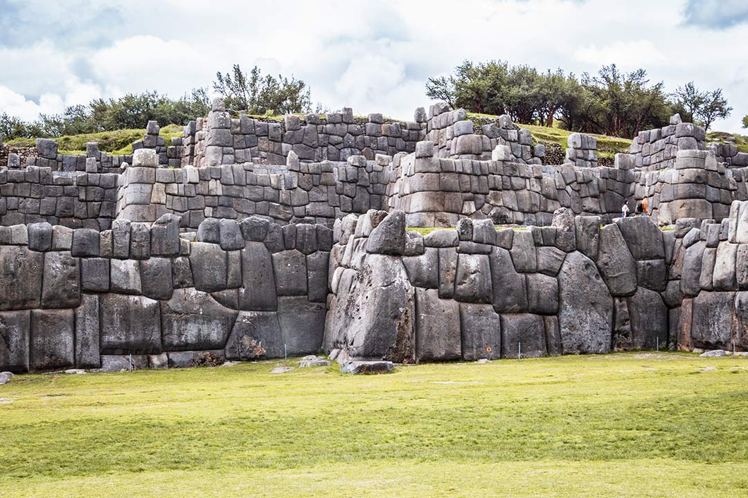 Poderosa vista de la fortaleza de Sacsayhuaman. Hay piedras unidas perfectamente, sobre la ladera de una montaña.