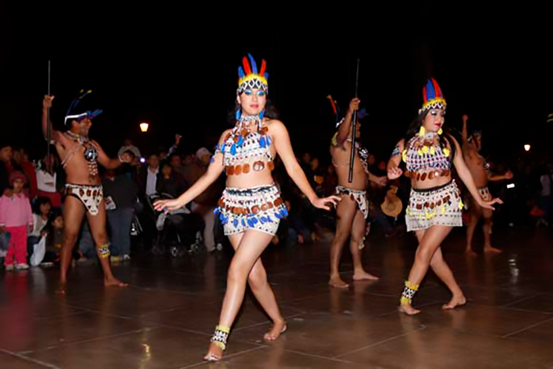 Vista nocturna de mujeres bailando la Fiesta de la Anaconda