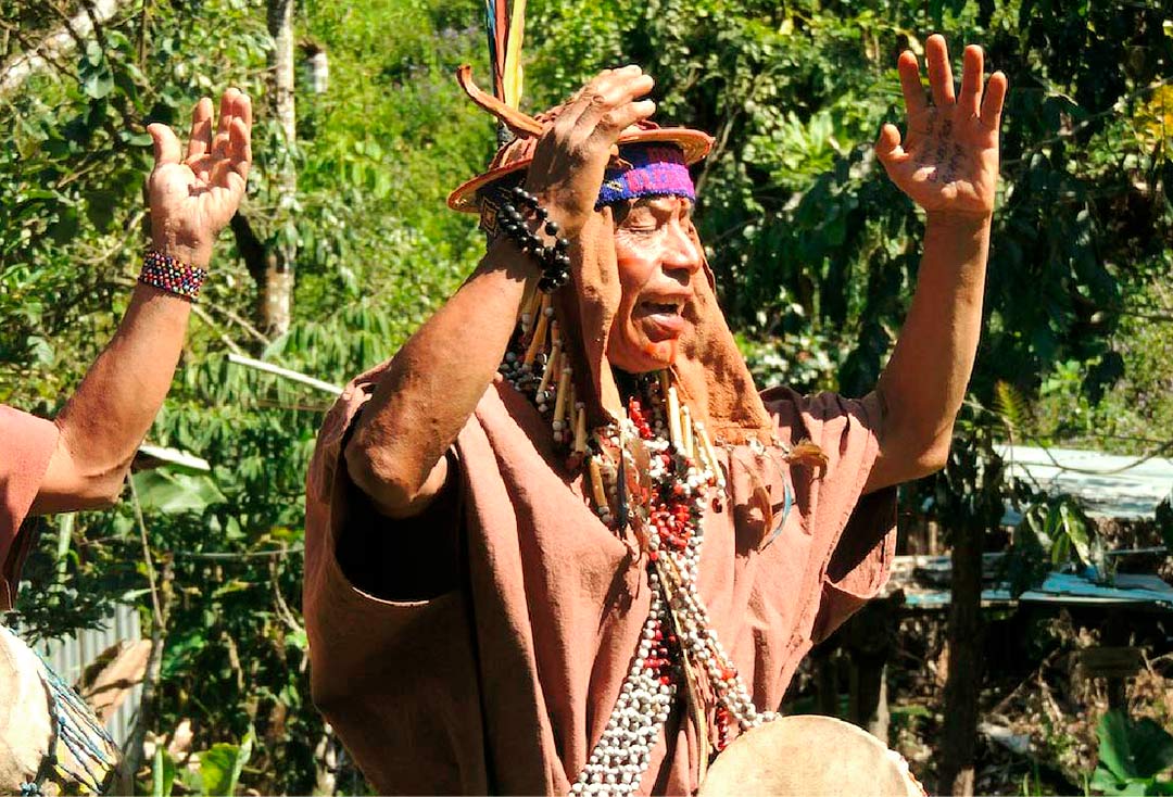 Un hombre vestido folclóricamente, bailando Danza de la Ayahuasca