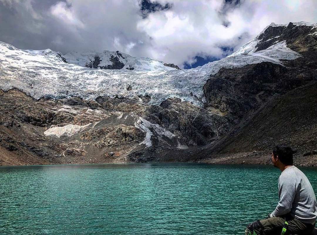 Un hombre se encuentra contemplando una laguna a los pies del Nevado Huaytapallana