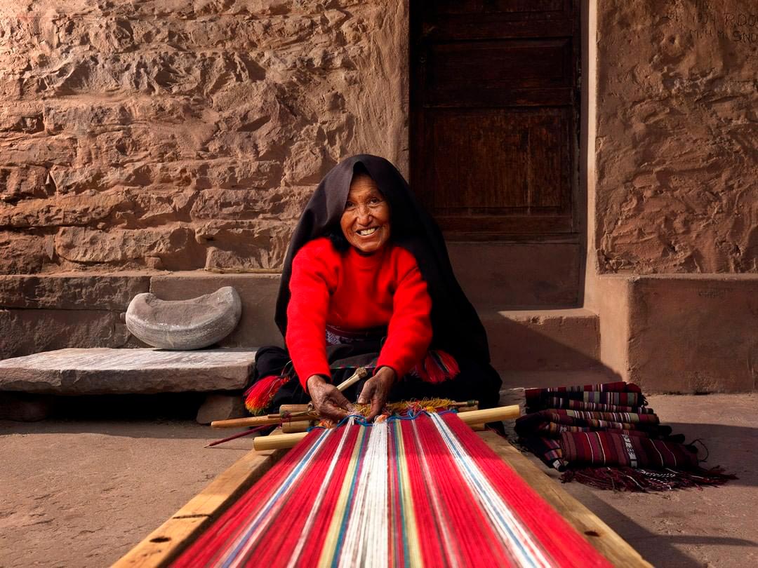 Mujer vestida de rojo exponiendo su textilería