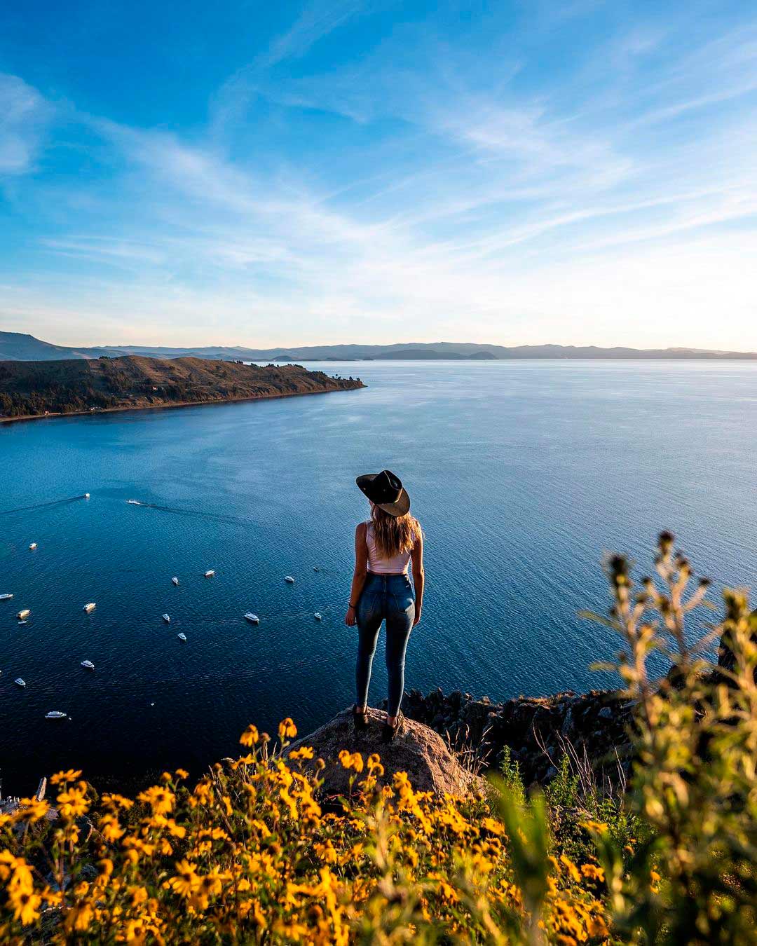 Joven contemplando las aguas del Titicaca, sobre un peñasco, en la Isla de Taquile