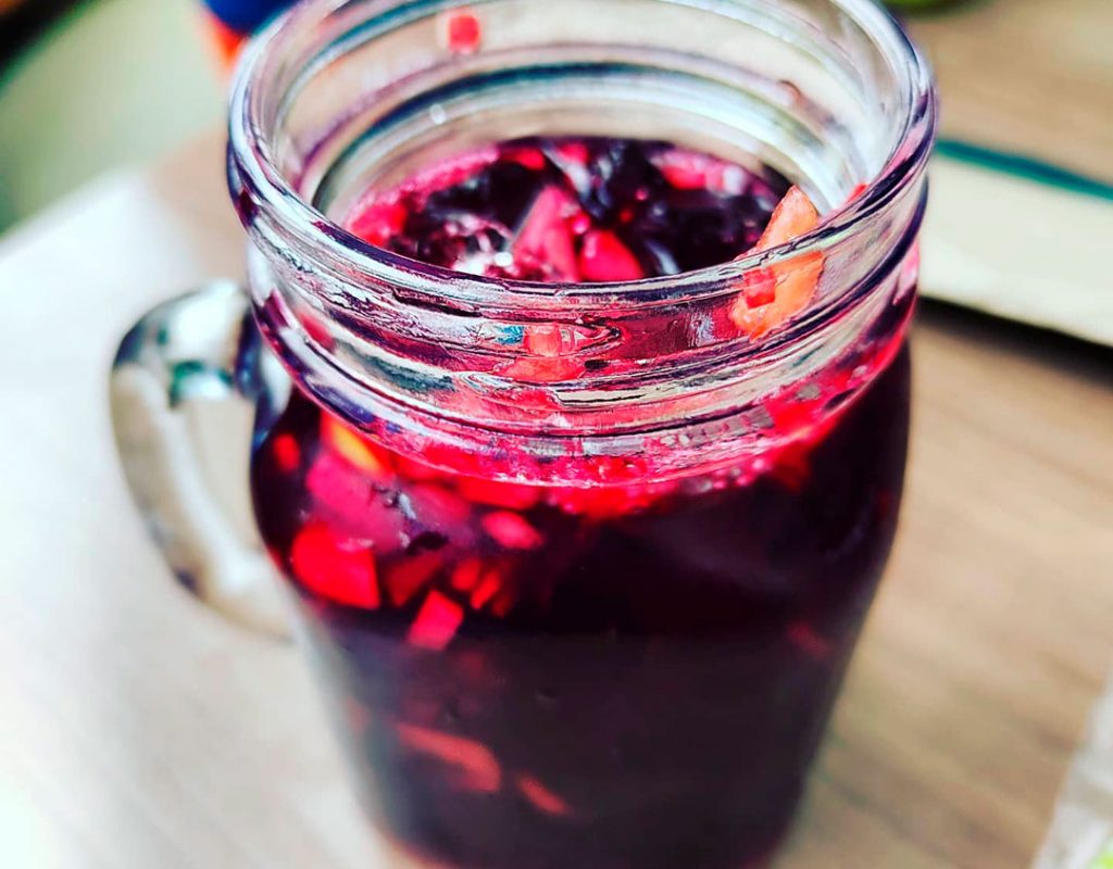 Chicha morada, dentro del vaso pedasitos de manazana